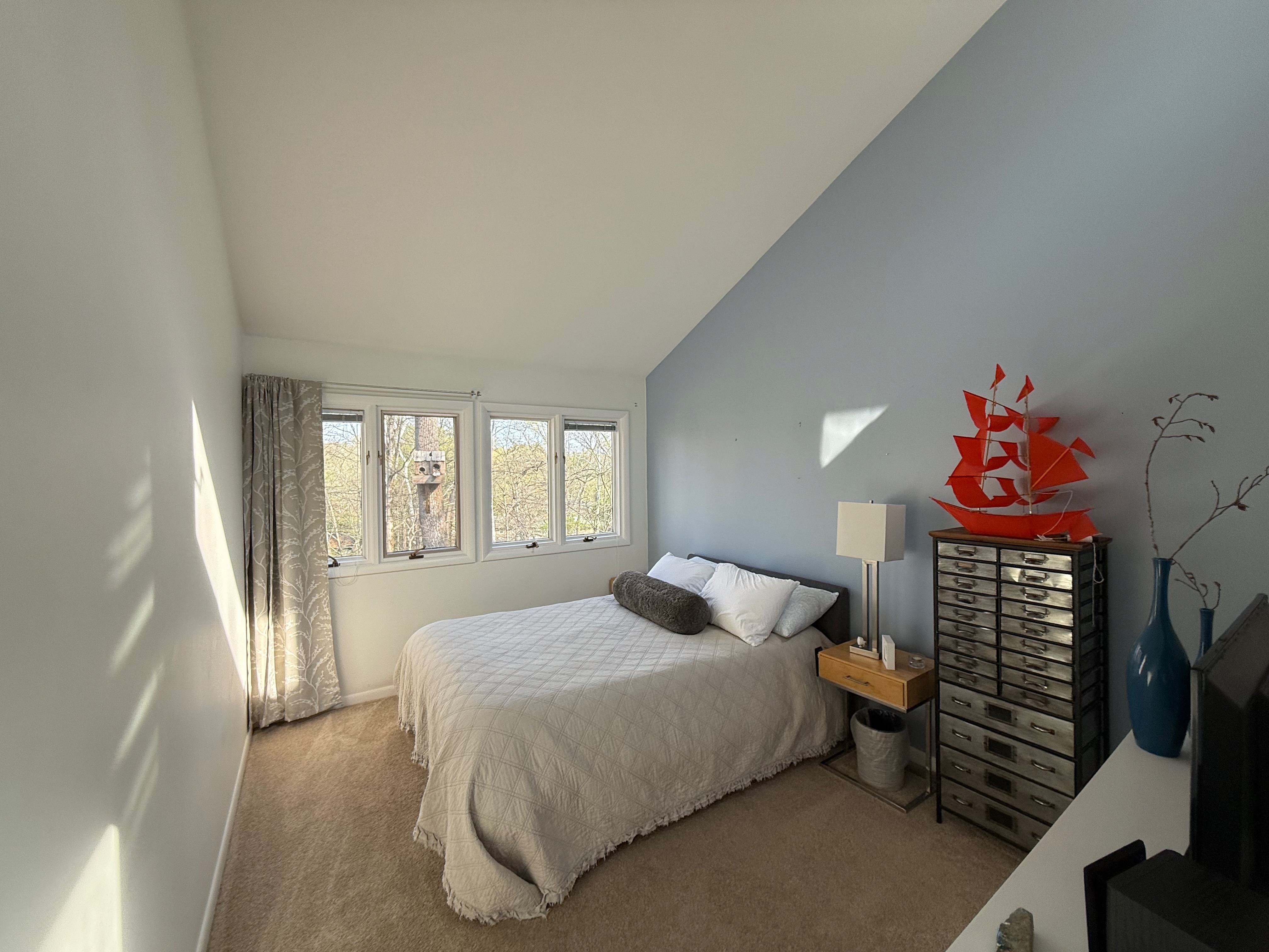 Guest bedroom with queen bed and blue accent wall